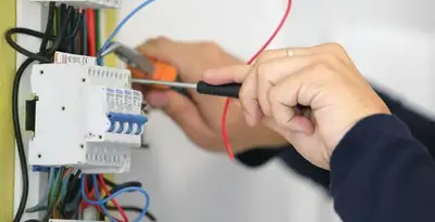 Electrician installing and adjusting circuit breakers in an electrical panel in Palm Springs, CA