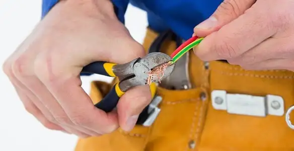 licensed electrician securing electrical wiring with professional tools during service work in Palm Springs, CA